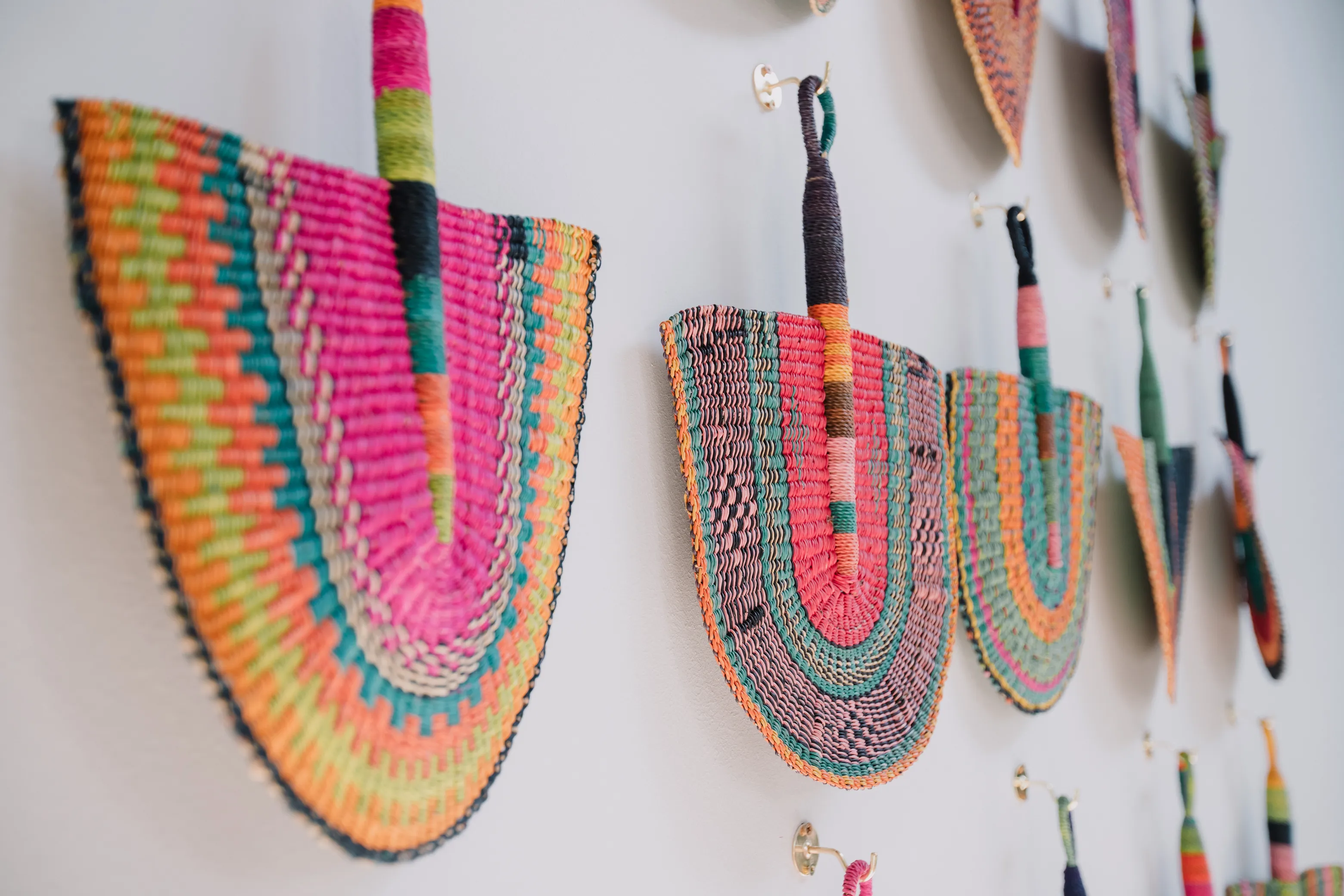 Colorful woven African decorations hung on a wall.
