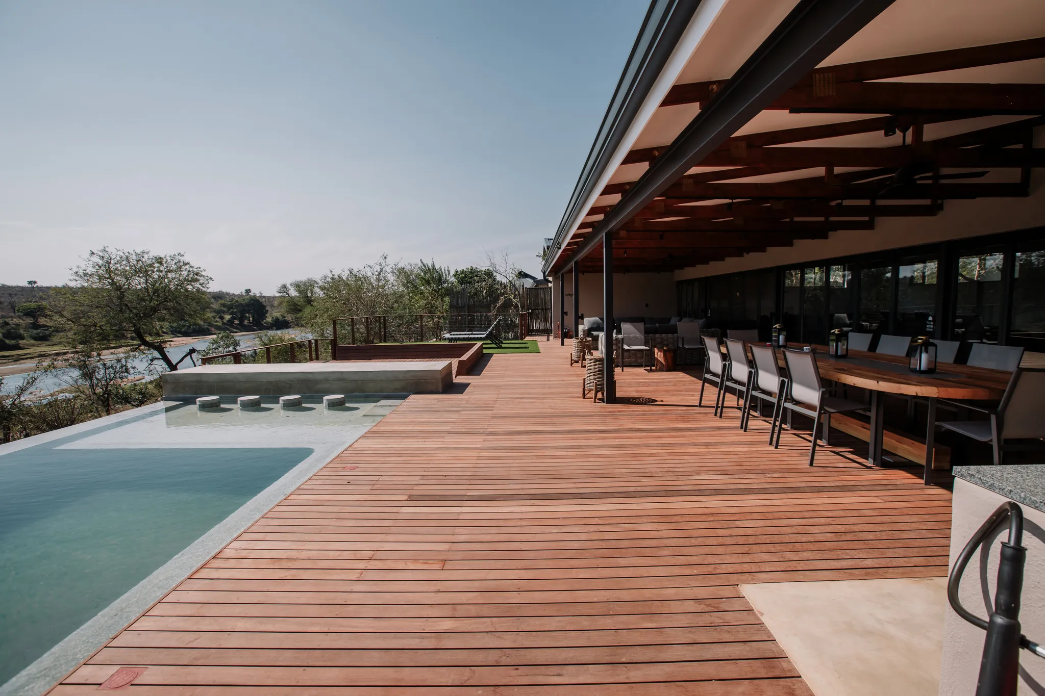 View of the pool area and covered patio with outdoor furniture.