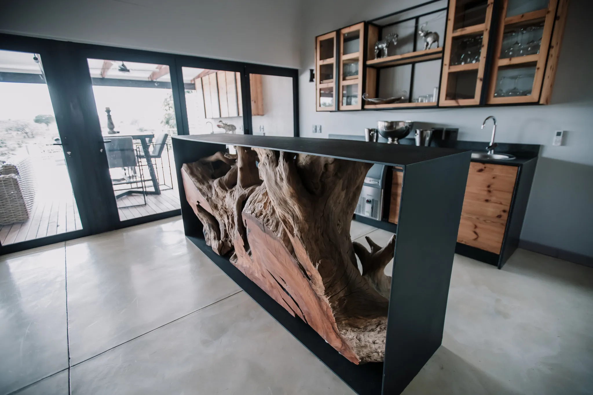 A kitchen with a custom made counter that has a tree log built into it.