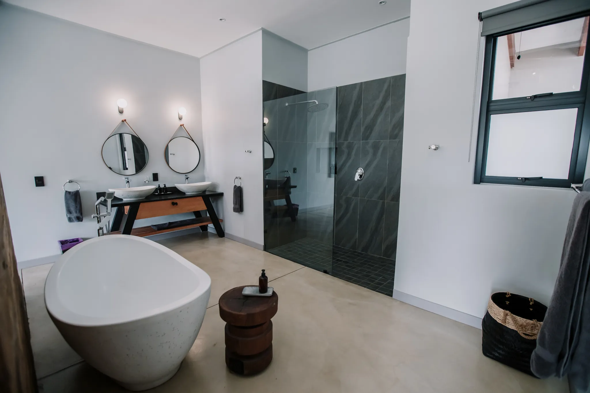 A large bathroom with a freestanding bath, large shower and two sinks.